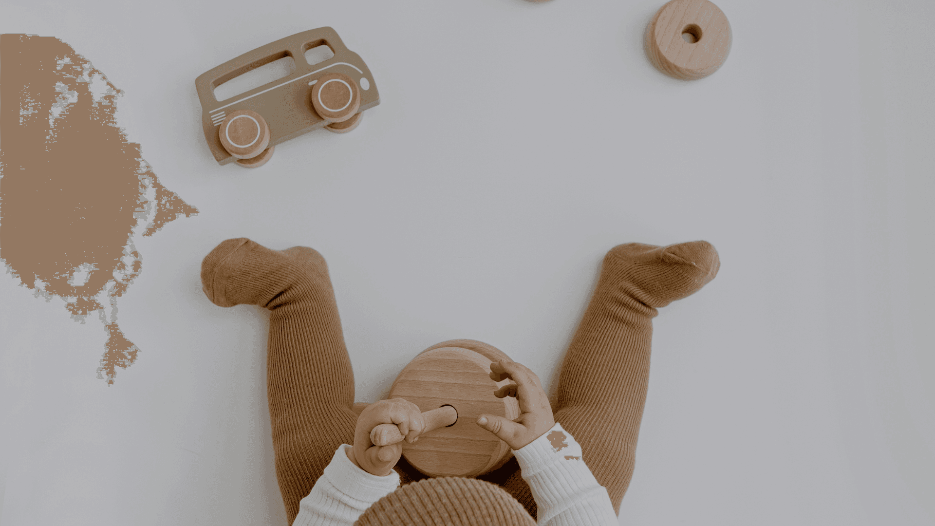 Baby speelt rustig met houten speelgoed op de grond